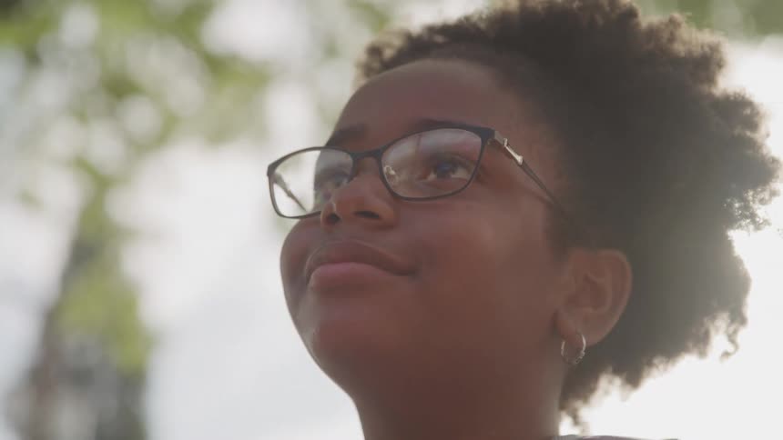 Curly haired woman with glasses outdoors