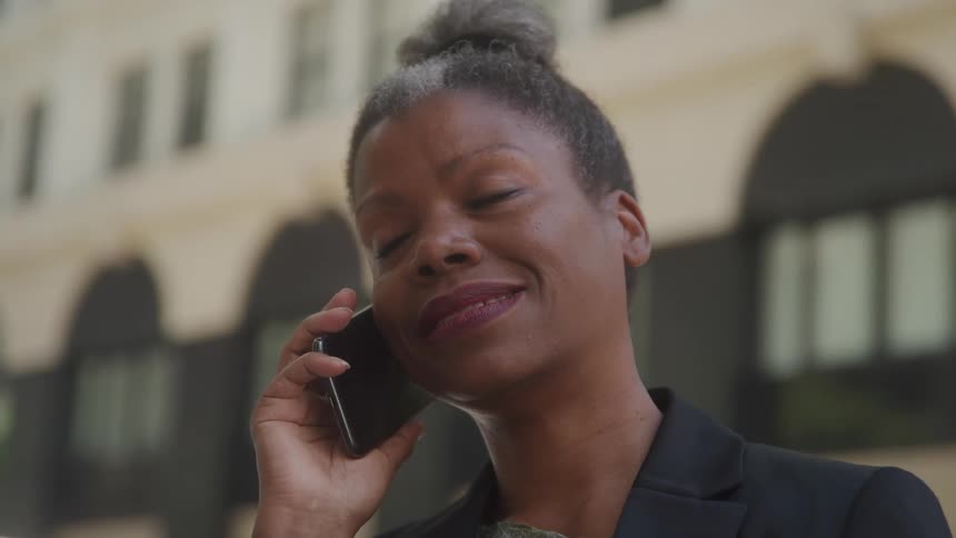 A woman making a call on mobile phone while standing outdoor in the morning