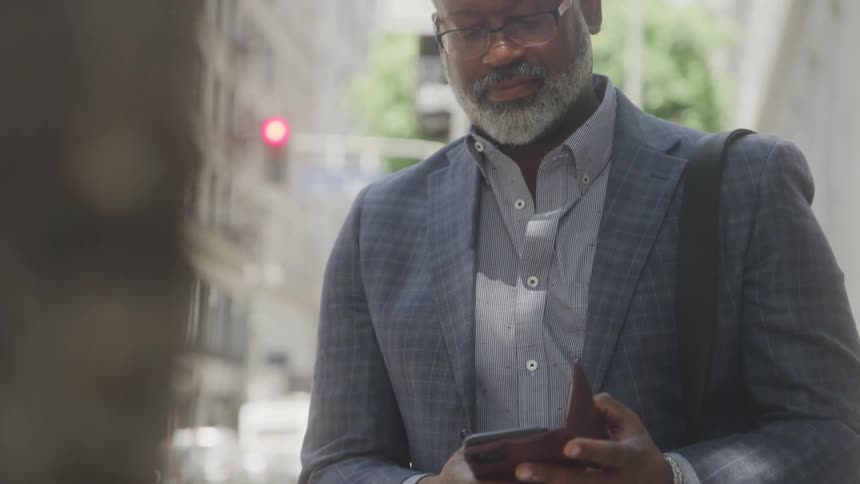 Man in suit outdoors interacting with a smartphone