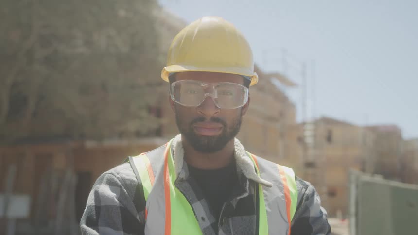Construction worker stands confidently at a work site