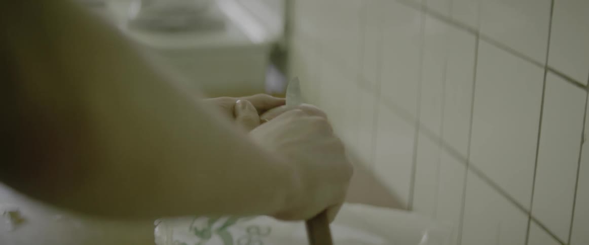 A person is peeling a potato in the kitchen
