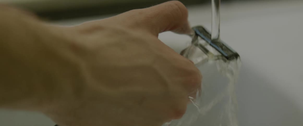 A razor is rinsed in a bathroom sink