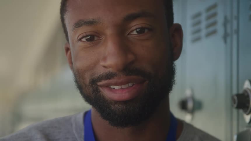 Man smiles as he turns his head to look at the camera