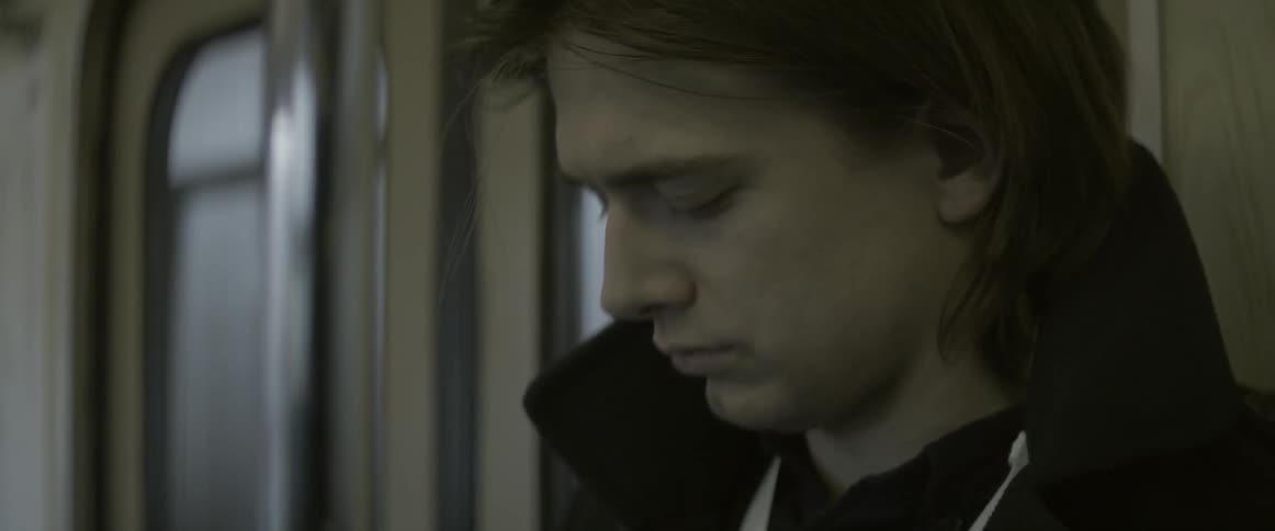 A long haired man is riding the bus