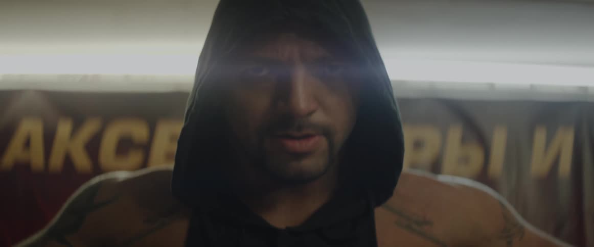 A man with a hood inhales and exhales deeply
