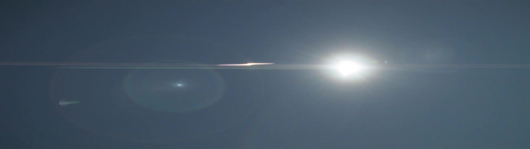 Ahead at dawn are many hills with an eclipse in the sky