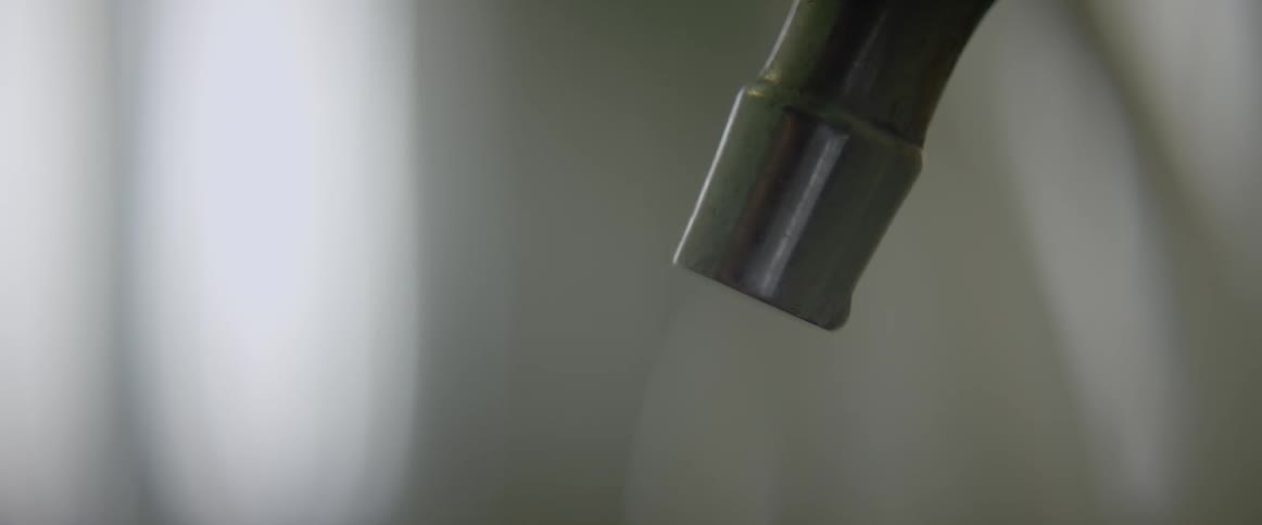 Water slowly drips from a faucet