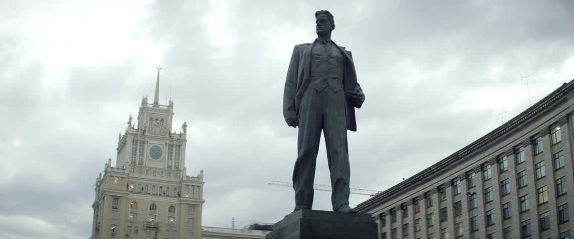 A statue of a man sits in front of a building