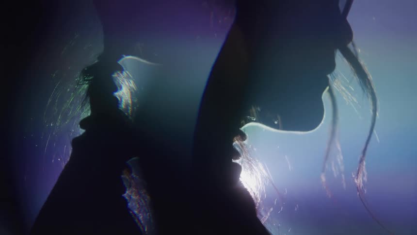 A young woman inside a dark nightclub with flickering lights