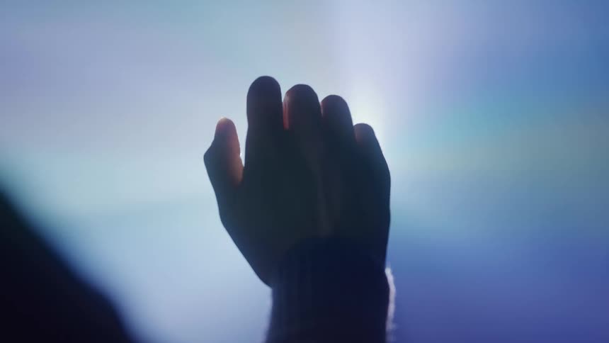 A person moves their hand in front of a light beam