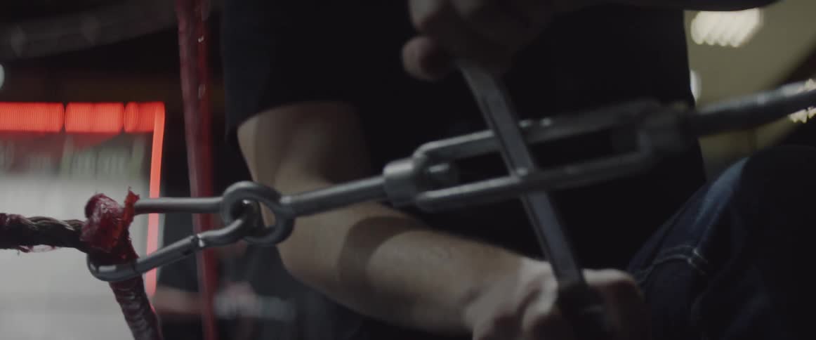 A man adjusts wrestling ring ropes