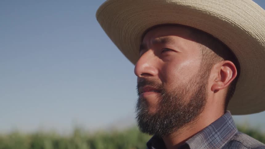 Close up portrait of a male farmer standing outdoors on a field during daytime
