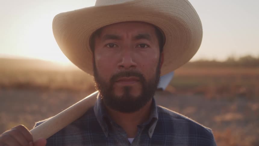 Farmer in a hat in a field at dawn