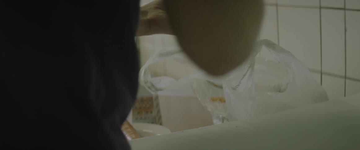 A person is cutting a carrot in a kitchen