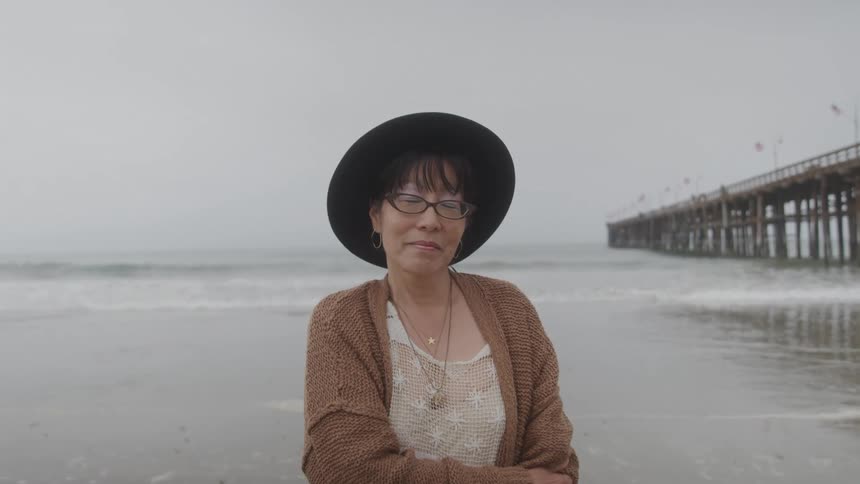 Portrait of an asian woman standing outdoors at the beach during daytime