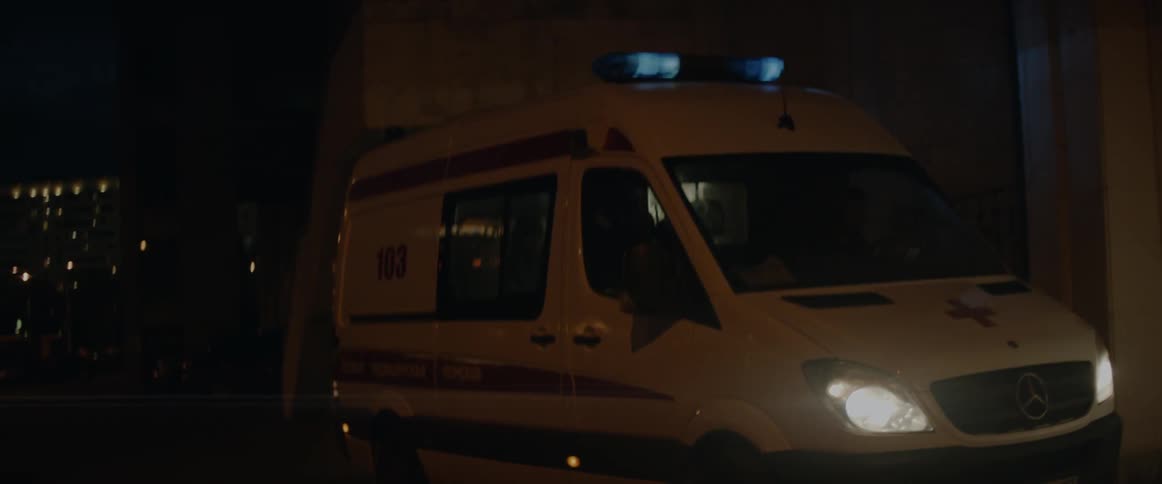 The lights on an ambulance blink at night