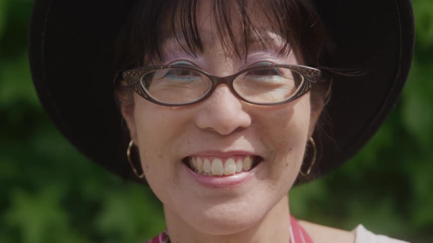 Woman in hat and glasses with happy expression