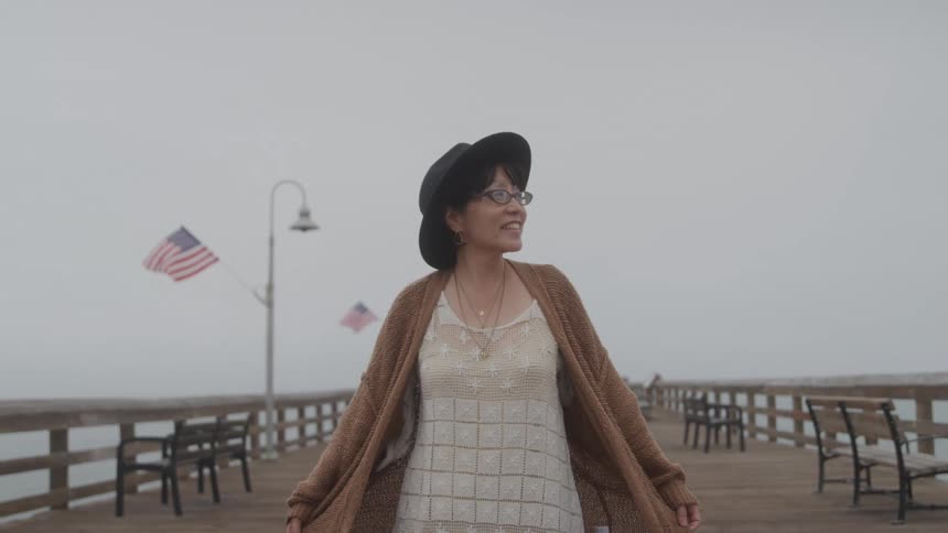 A woman walks down a boardwalk