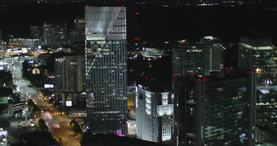Tall buildings fill this city with traffic all around at night
