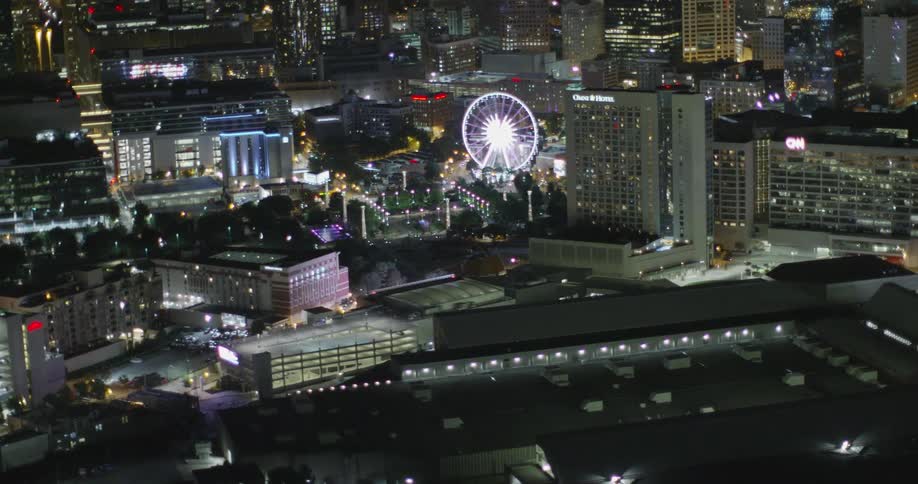 A ferris wheel and skyscrapers light up the city skyline