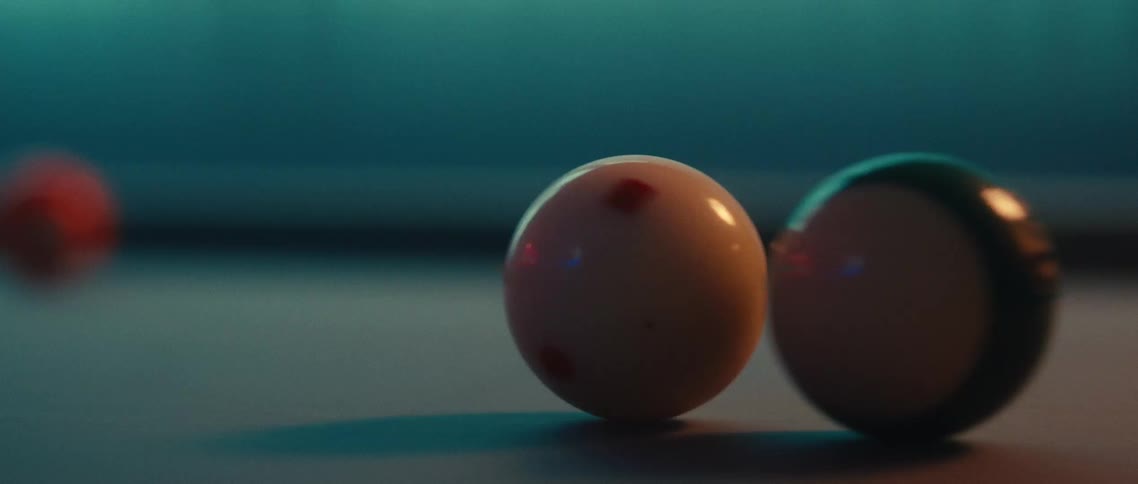 A white cue ball rolling and hitting another pool ball