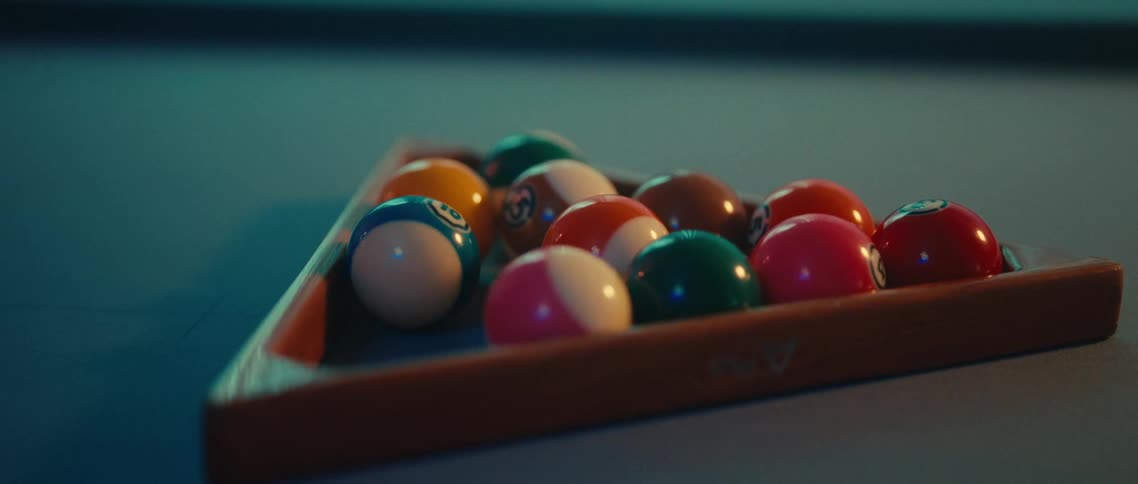 Pool player uses a rack to place the billiard balls into the starting position