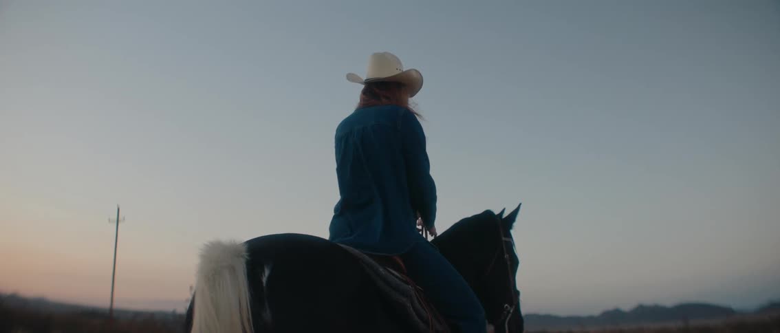 The woman is riding a horse outside
