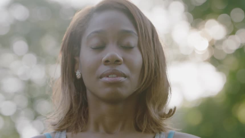 A woman closes her eyes and breathes deeply