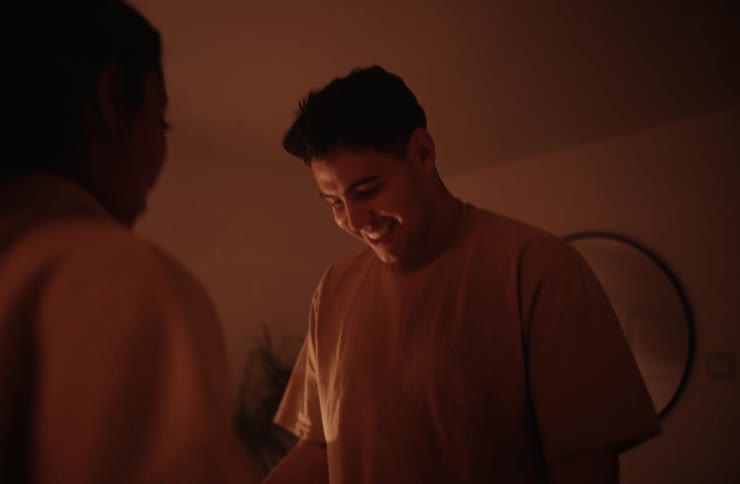 A couple in their living room at night dancing and holding each other with excitement