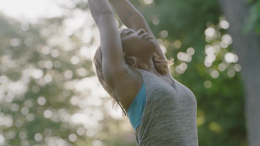 A woman does yoga outside on a sunny day