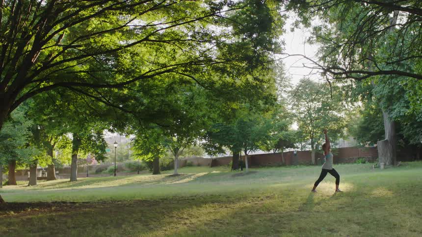 A woman is doing yoga in a park