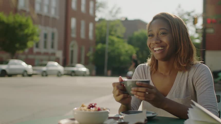 Two women chat and drink tea outside on a sunny day