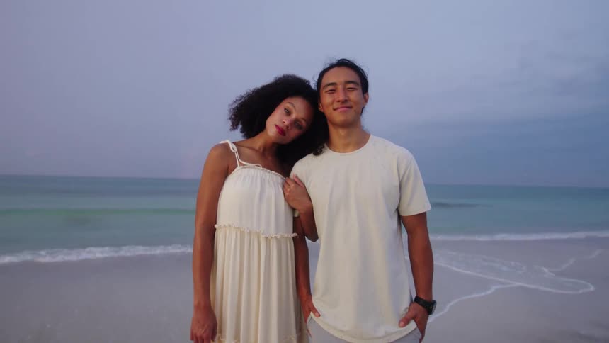Couple in white together romantically on the beach