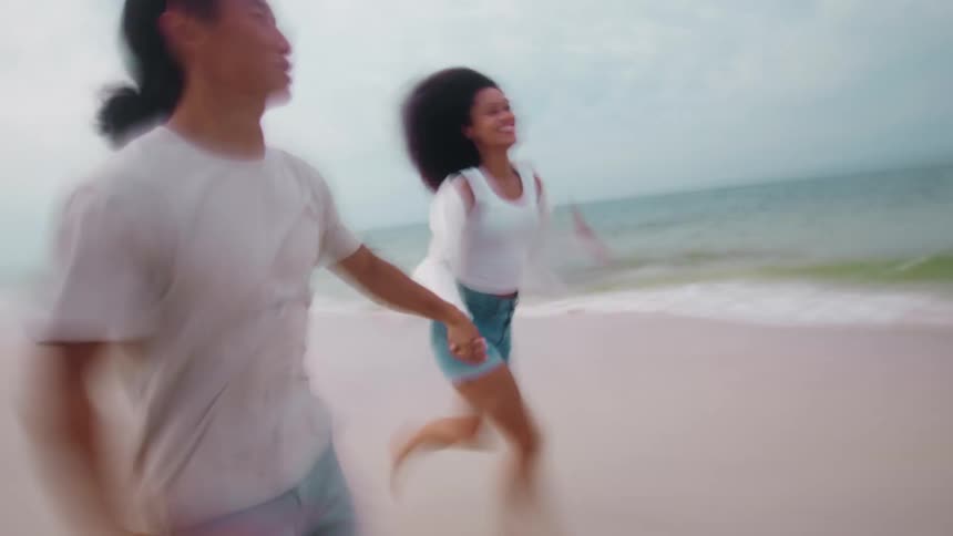 Two friends run on the beach together
