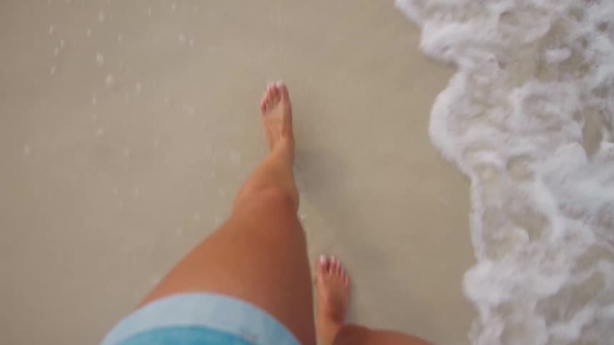 Legs of a woman walking on the beach