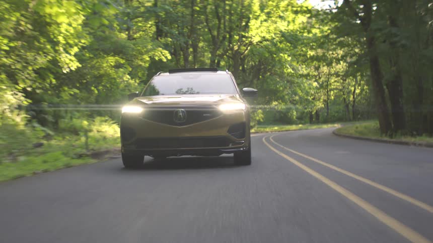 Suv car traveling on a paved road surrounded by trees