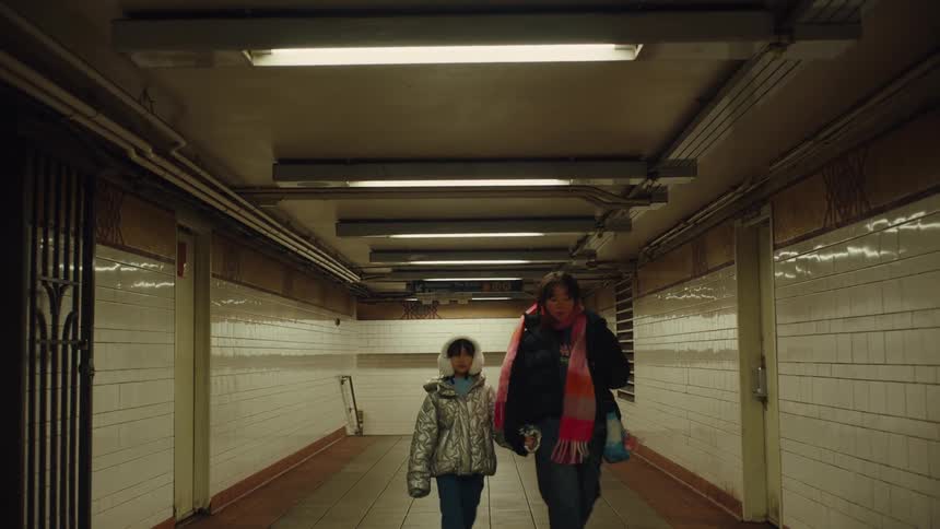 Mother and daughter walking down the hallway of a train station