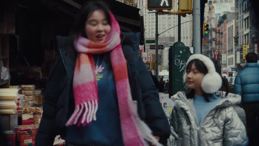 A mother holding her young daughters hand while crossing the street