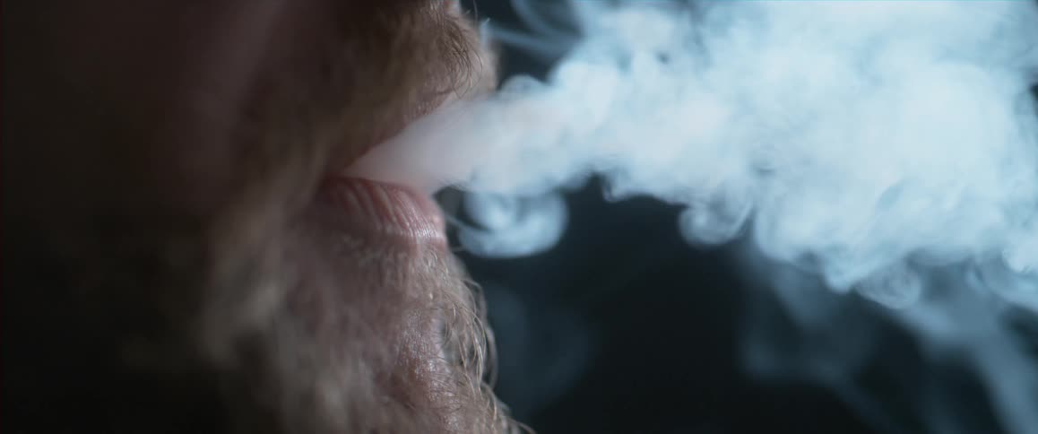 Man smoking a cigarette and exhaling smoke