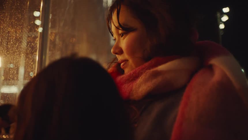 A woman traces on the wet window with her finger