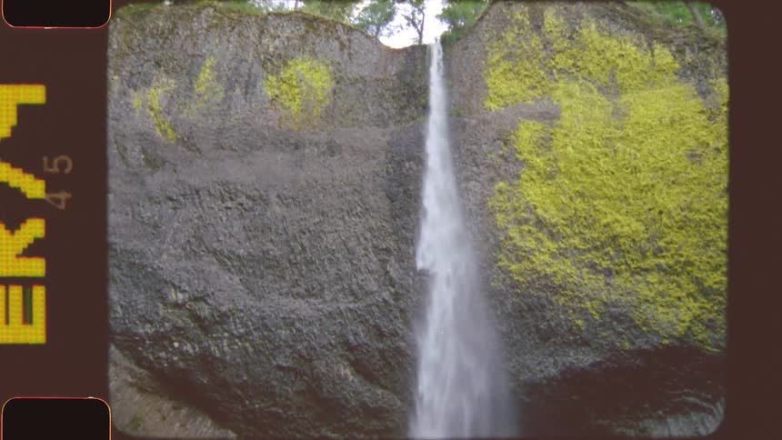 A waterfall flowing from a rock to the ground at midday in the jungle