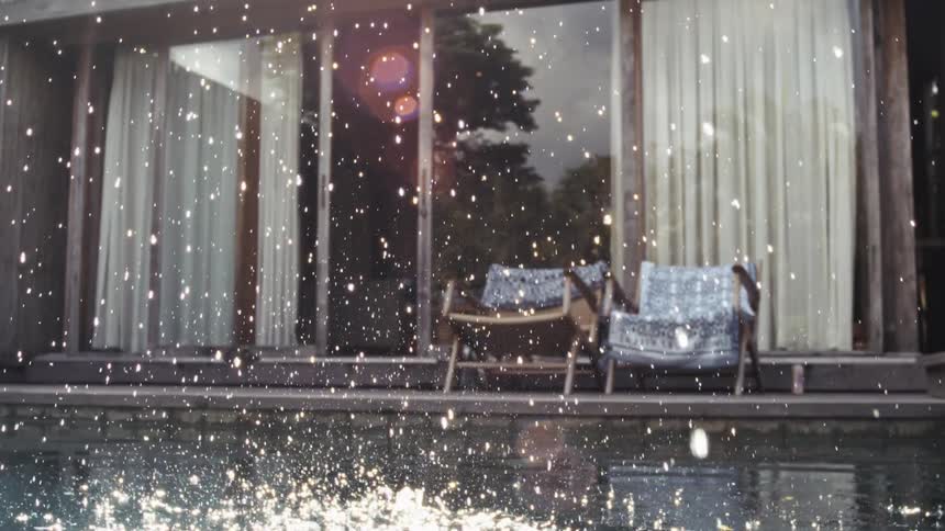 A rock hits the outdoor pool inside a resort causing a splash at midday