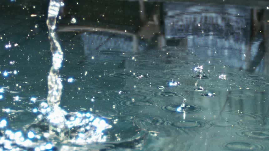 A rock falls into some clear water