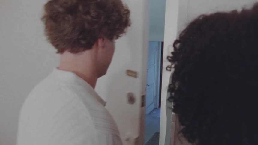 A man talking to two people inside his apartment one of them shuts the door in his face