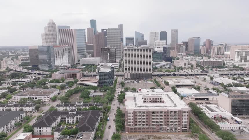 Aerial view of a large city with tall buildings in the downtown area and residential neighborhoods surrounding it