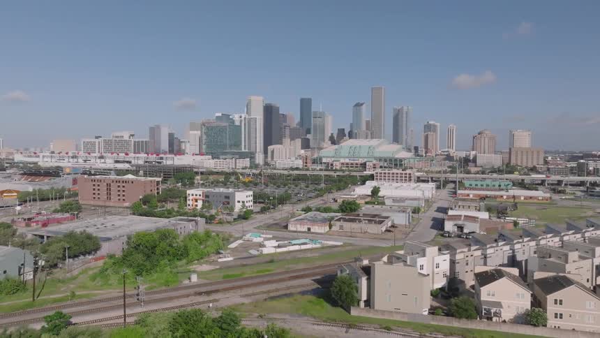 Aerial view of a suburb in the foreground and skyscrapers of a metropolis in the background