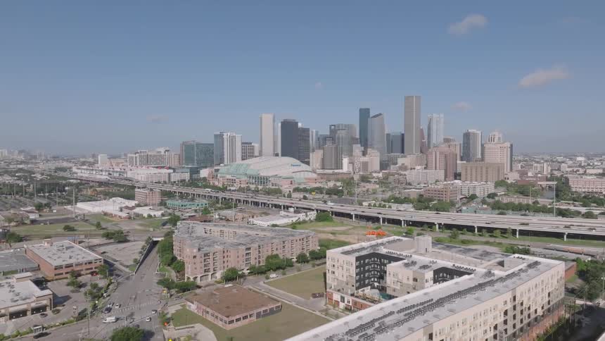 Aerial view of a modern city skyline with surrounding urban infrastructure