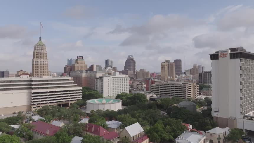 Aerial view of a city with several tall buildings and a partly cloudy sky