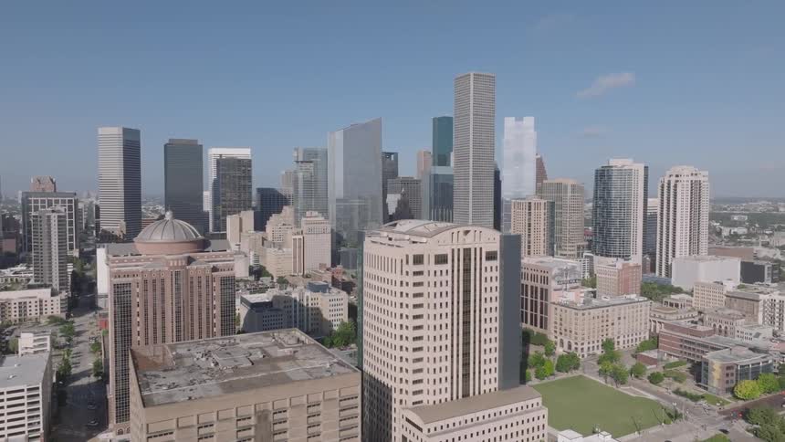 A city skyline with a series of highrise buildings and skyscrapers at midday
