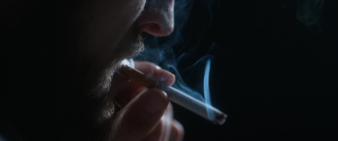Man with a beard smoking a cigarette